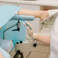 Lekarz wykonuje gbs badanie, pobierając wymaz z szyjki macicy.