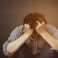 Mężczyzna w rozpaczy, trzymający się za głowę. Może to być symbol trudności związanych z uzyskaniem zaświadczenia od psychologa do rozwodu.