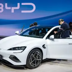 Weißer BYD Seal auf einer Messe, Leute steigen ein. Die BYD Aktien könnten bald steigen.