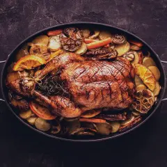 Ein goldbraun gebratener Gansbraten mit Kartoffeln, Orangen und Knoblauch. Die Frage welcher Wein zu Ente passt, wird hier kulinarisch beantwortet.
