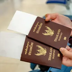 Zwei Reisepässe von Thailand werden gehalten, bereit für die Einreise. Ein 10-Jahres-Visum Thailand ist vielleicht schon beantragt.