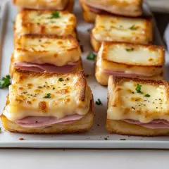Petits croque-monsieur gratinés, une délicieuse entrée jambon et fromage fondant, parsemés de persil frais.