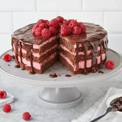 Himbeertorte mit Schokoboden, üppig mit Schokolade überzogen und mit frischen Himbeeren garniert. Ein köstlicher Anblick!