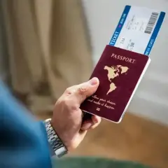 Ręka trzyma paszport i bilet lotniczy. Czy na Cypr potrzebny jest paszport? Sprawdź przed podróżą!