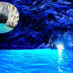 Un piccolo barca entra nella magica gruta azul, illuminata da un'intensa luce blu che riflette sull'acqua cristallina.