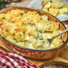 Herzhafter blumenkohl auflauf mit Kartoffeln und Käse überbacken, dampfend in einer Auflaufform.