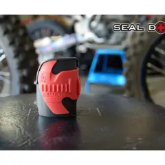 Herramienta roja para reparar horquilla moto, con logo "Seal Doctor" al fondo.