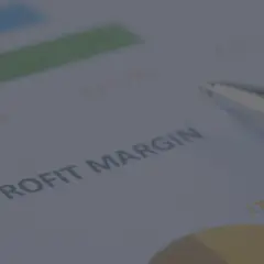 Długopis na dokumencie z wykresem i tekstem "PROFIT MARGIN". Analiza danych, jak obliczyć marżę, by zwiększyć zyski.