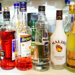 Na półce stoją butelki z alkoholami: Aperol, Malibu, Puschkin, Freixenet Cava i inne. Czy Schweppes ma alkohol? Nie ma go na zdjęciu.