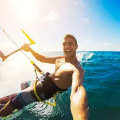 Szczęśliwy facet na kitesurfingu robi selfie. Wskazówka, jak zrobić dobre selfie facet: uśmiech i akcja!