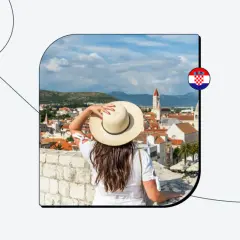 Kobieta w kapeluszu podziwia widok na chorwackie miasto. Czy do Chorwacji potrzebny jest paszport? Sprawdź!