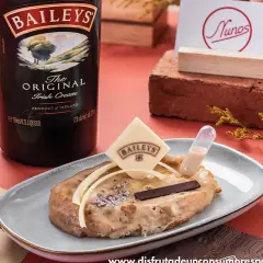 Torrijas de Baileys, un postre cremoso con un toque de licor irlandés, decorado con chocolate y una pipeta de salsa.