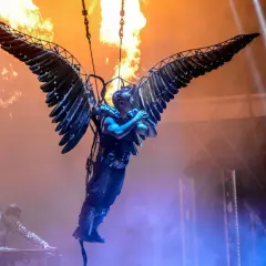Till Lindemann z Rammstein, zawieszony w powietrzu na skrzydłach, śpiewa na tle płomieni. Jego utwory to ogień i moc.