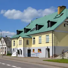 Kolorowe kamienice w Sejnach, z zielonymi dachami i licznymi oknami, tworzą urokliwy krajobraz. To jedne z wielu atrakcji Sejn.