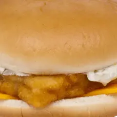 Chrupiący fish mac z serem i sosem tatarskim, zamknięty w miękkiej bułce.