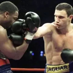 Vitali Klitschko boxing match, throwing a punch. His opponent is defending.