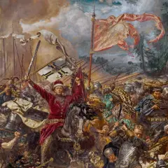 Jan Matejko ukazuje dynamiczną bitwę pod Grunwaldem. W centrum rycerz w czerwieni unosi miecz i chorągiew.