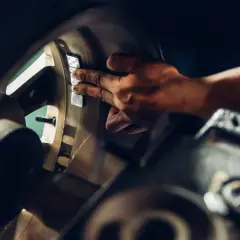 Mechanik przykleja ciężarki do felgi, by wyeliminować drgania kierownicy przy 120 km/h.