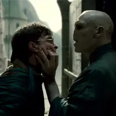 Ralph Fiennes jako Voldemort grozi Harry'emu Potterowi, chwytając go za twarz.