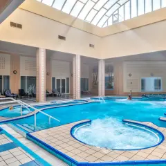 Wnętrze basenu z hydromasażem w Mahdia Palace. Woda jest turkusowa, a wokół basenu znajdują się leżaki.