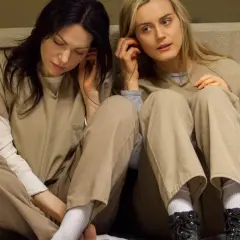Dwie kobiety w więziennych strojach słuchają muzyki. To scena z serialu "Orange Is the New Black", popularnego filmu o lesbijkach na Netflix.