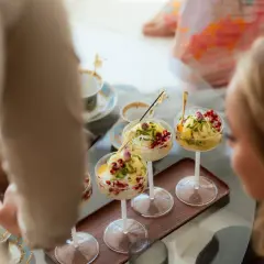 Tre skålar med bastani sonnati, en persisk glassdessert, toppad med granatäppelkärnor och pistasch.
