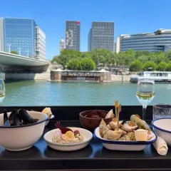 Dégustation de fruits de mer et vin blanc avec vue sur la Seine. L'endroit parfait pour les best moules frites Paris.