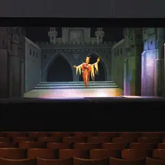 Eine gruselige Figur steht auf der Bühne von Gerhards Marionettentheater vor einer Burgkulisse.