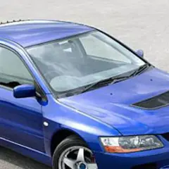 Niebieski Mitsubishi Lancer Evo 9 z charakterystycznym wlotem powietrza na masce i dużym spojlerem, gotowy do akcji.