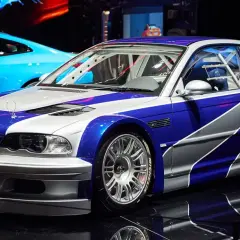 Wyścigowe BMW M3 GTR w niebiesko-srebrnym malowaniu, gotowe do akcji.