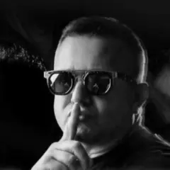 Dj Diesel w okularach z palcem na ustach, sugeruje ciszę przed nadchodzącym hitem.