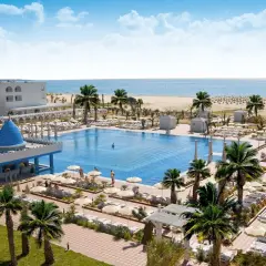 Luksusowy hotel Occidental Marco Polo nad morzem, z basenem, palmami i plażą.