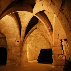 Cave voûtée de la maison Taittinger à Reims, où des milliers de bouteilles de champagne vieillissent patiemment.