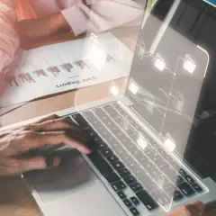 Des mains travaillent sur un ordinateur portable affichant une structure de dossiers numériques, symbolisant les sae archives.