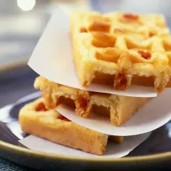Trois gaufres rectangulaires empilées, garnies de petits morceaux de chorizo.