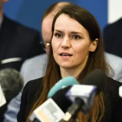 Agnieszka Pomaska przemawia do mediów. W tle widać mężczyzn, być może jej rodziców lub współpracowników.