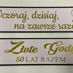 Dwie tablice z napisem "Wczoraj, dzisiaj, na zawsze razem" i "Złote Gody 50 lat razem" upamiętniające 50 rocznicę ślubu.