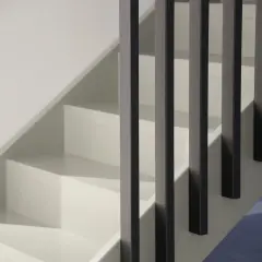 Renovering av en vit trappa inomhus med mörka räcken. En stilren och modern känsla.