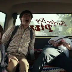 Czterech przerażonych przyjaciół z Stranger Things 4 krzyczy w vanie, gdy przejeżdżają obok Surfer Boy Pizza.