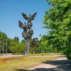 Pomnik Czynu Polaków w Szczecinie, jedna z głównych atrakcji miasta, w otoczeniu zieleni i kwitnących kwiatów.