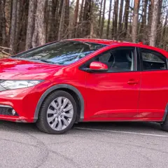 Czerwony Honda Civic UFO na leśnej drodze.
