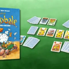 Gra karciana "Polowanie na Robale". Kura na deskorolce goni robaki. Karty z numerami i zabawnymi postaciami leżą na zielonym tle.