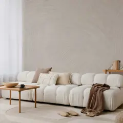 A serene japandi style home living room with a plush white sofa, wooden coffee table, and textured wallpaper.