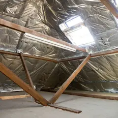 Isolation des combles : le prix au m2 dépend de la technique. Vue d'un grenier en cours d'isolation avec matériaux réfléchissants.