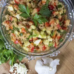 Insalata di amaranto colorata con pomodori, cetrioli e peperoni, guarnita con prezzemolo fresco.