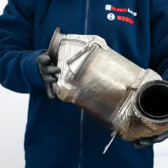 Mechanik w rękawiczkach trzyma filtr DPF. Czy DPF to katalizator? To pytanie często zadawane przez kierowców.