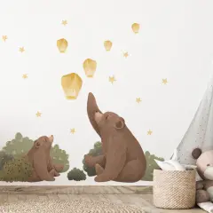 Urocza naklejka na ścianę miś i jego dziecko wypuszczają lampiony na nocnym niebie.