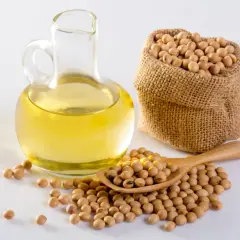 Szklana karafka z olejem, obok worek i drewniana łyżka pełne ziaren soi. Naturalny olej sojowy, źródło zdrowia.