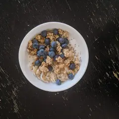 Un bol de skyr avec des myrtilles, des rondelles de banane et du granola. On peut chauffer le skyr pour un petit-déjeuner réconfortant.