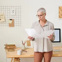 Kobieta analizuje dokumenty, szukając informacji o tym, ile wynosi renta na dziecko po śmierci ojca.